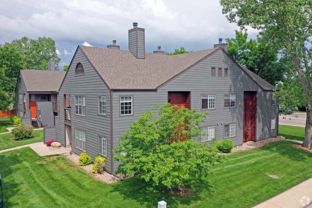 Building exterior with large trees and sidewalks