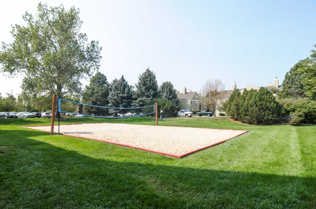 Volleyball Court with trees, plants, parked cars around