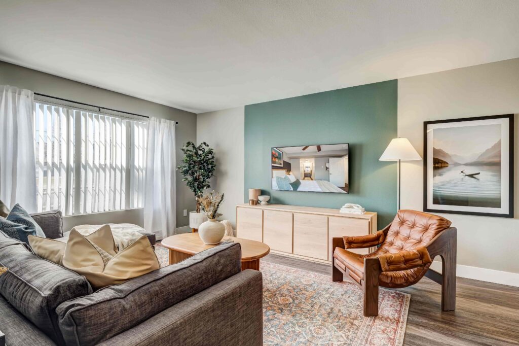 Living room with large window and green accent wall at Habitat at Fort Collins luxury apartments in Fort Collins