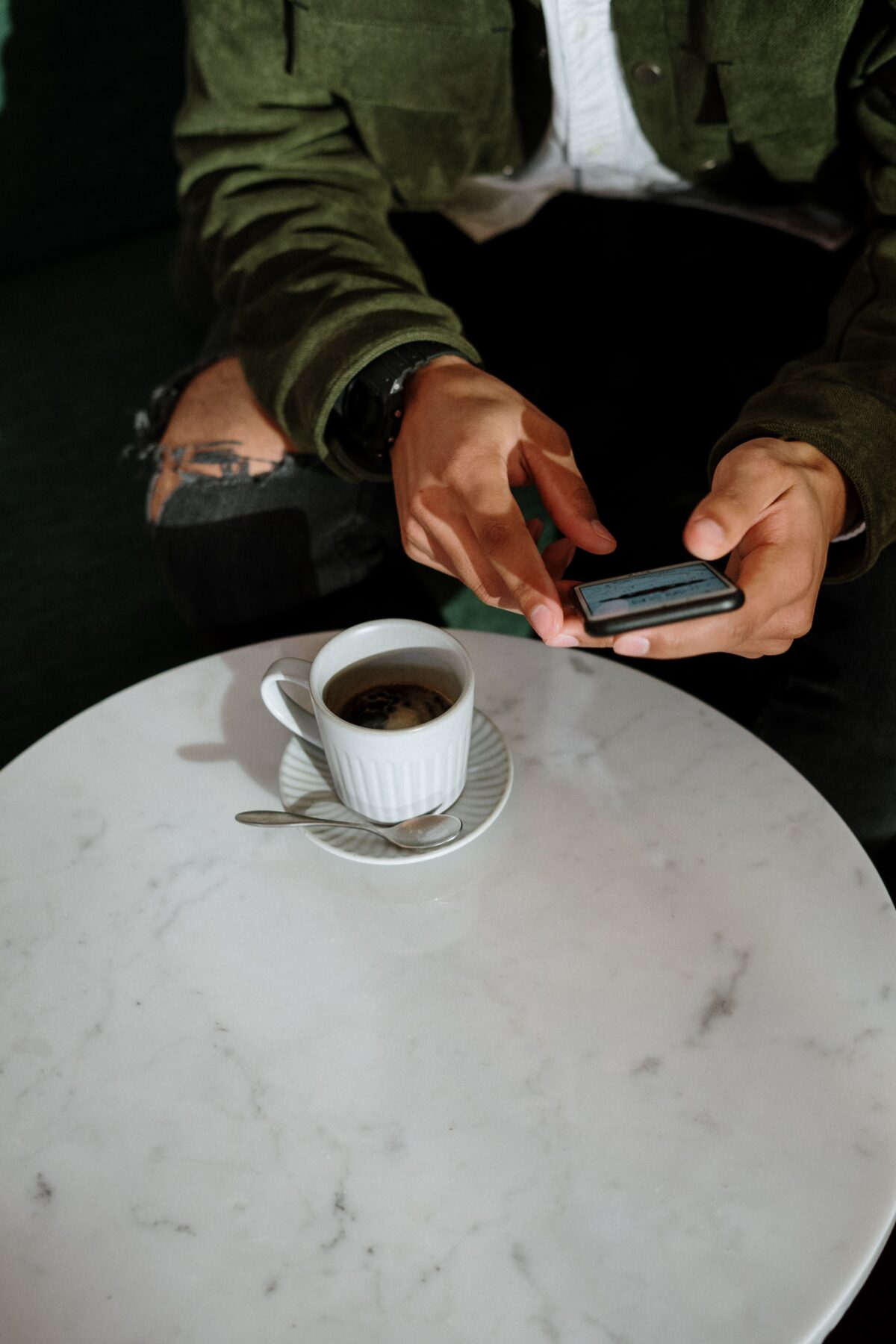person on their phone drinking coffee
