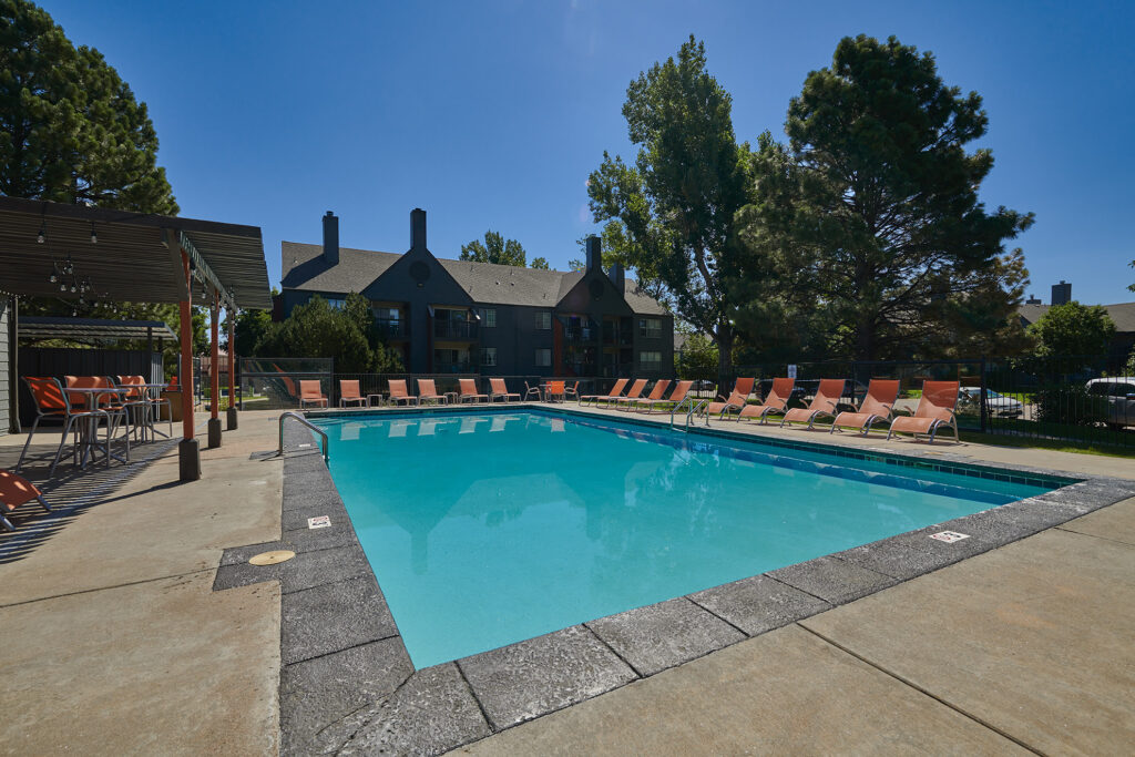Swimming pool with deck seating and shaded tables