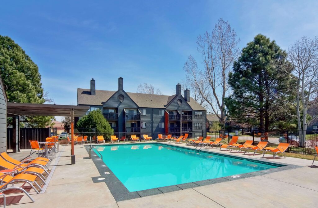 Swimming pool with deck seating and shaded tables