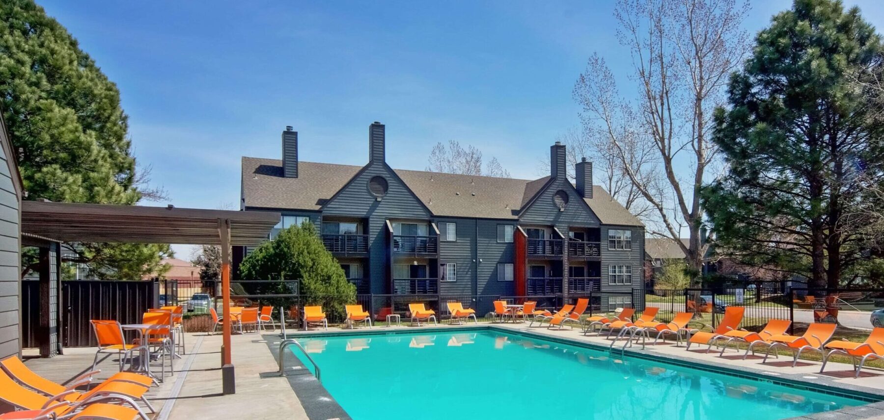 Swimming pool with deck seating and shaded tables