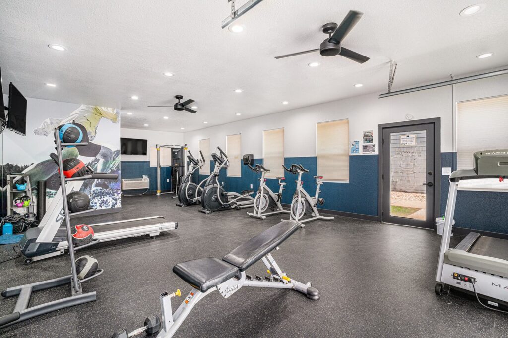 Fitness center with cardio equipment and overhead fans
